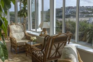 a room with two chairs and a table and windows at Sure Hotel Collection by Best Western Porth Veor Manor Hotel in Newquay
