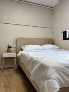 a bedroom with a large white bed and a table at Vila Lidar in Eilat +28 photos