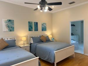 a bedroom with two beds and a ceiling fan at Anna Maria Island-Blue Manatee in Bradenton +40 photos