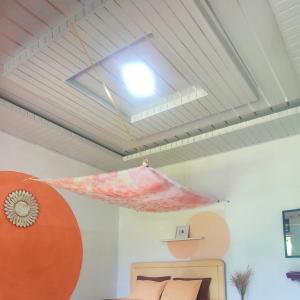 a ceiling light in a room with a bed at Sarah's Cottage Toba Samosir in Ambarita