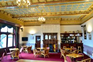 uma sala de jantar com mesas e cadeiras e um tecto em The County Hotel em Carlisle