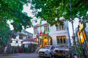 two cars parked in front of a building on a street at The K11 Hotels - T Nagar in Chennai