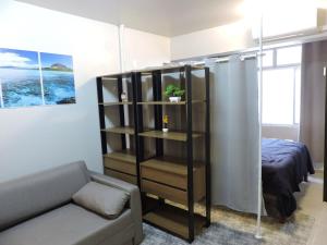 a living room with a couch and a book shelf at Conforto e facilidade a uma quadra do mar! in Capão da Canoa +10 photos