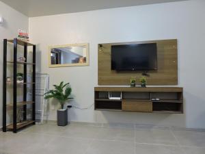 a living room with a flat screen tv on a wall at Conforto e facilidade a uma quadra do mar! in Capão da Canoa