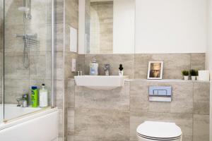 a bathroom with a shower and a toilet and a sink at New-Build 1-Bed Apartment in Luton in Luton +13 photos