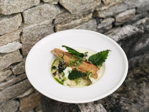 a white plate with a dish of food on a wall at Die neue Weizerhütte in Sankt Kathrein am Offenegg