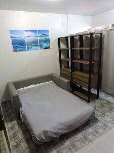 a bedroom with a bed and a book shelf at Conforto e facilidade a uma quadra do mar! in Capão da Canoa