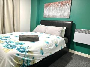 Bett in einem Zimmer mit grüner Wand in der Unterkunft Sterling Luxury Apartment City Centre -Sleeps 4-Juliet Balcony - WiFi in Birmingham