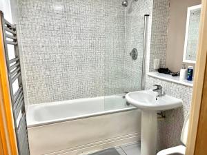 ein Badezimmer mit einer weißen Badewanne und einem Waschbecken in der Unterkunft Sterling Luxury Apartment City Centre -Sleeps 4-Juliet Balcony - WiFi in Birmingham + 35 Fotos