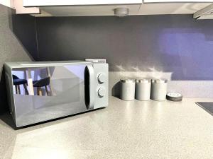 eine Mikrowelle auf einer Theke in einer Küche in der Unterkunft Sterling Luxury Apartment City Centre -Sleeps 4-Juliet Balcony - WiFi in Birmingham