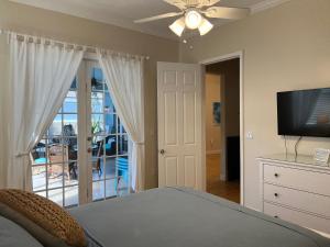 a bedroom with a bed and a flat screen tv at Anna Maria Island-Blue Manatee in Bradenton