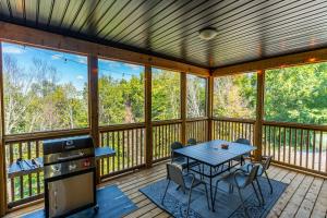 a screened in porch with a table and chairs at Northern Light Retreat|HotTub|Sauna|GamesRoom in Dwight