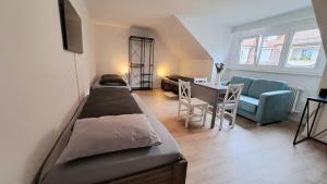 a room with three beds and a table and a couch at Casa Maria Apartments Bern in Bern