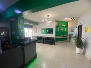 a living room with green walls and a couch at Limeira Plaza Hotel in Limeira
