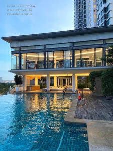a large house with a swimming pool next to a building at La Gente Comfy Stay 2r2b Velocity - Kl City View in Kuala Lumpur