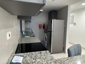 a kitchen with a sink and a refrigerator at Pinnacle Row Seaview Elegance in Muscat +9 photos