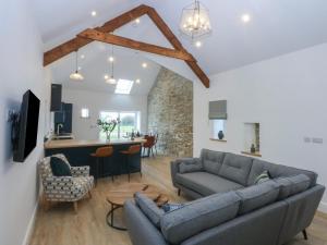 LlanfachraethにあるBeudy Tanralltのソファとテーブルのあるリビングルームとキッチン
