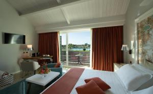 a hotel room with a bed and a large window at Wellness Spa Hotel Principe Fitalia in Syracuse