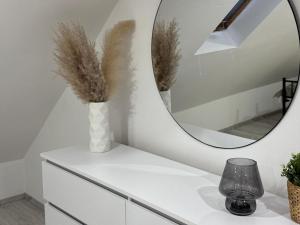 a mirror on top of a dresser with a vase at M B Homes Lauterstein 10 in Lützelalb