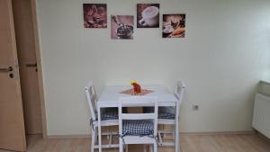 a white table and chairs in a room with pictures on the wall at Haus am Schaumberg in Tholey