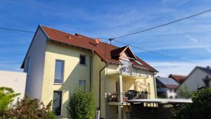 a yellow house with a red roof at Haus am Schaumberg in Tholey