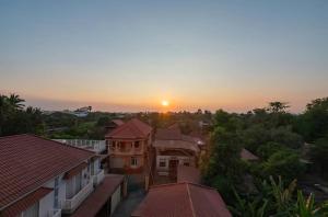 a sunset over a city with houses and trees at Flex Suites in Phum Pobos