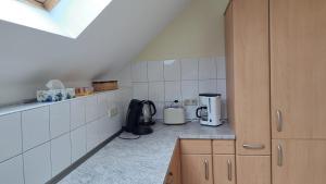 a small kitchen with white tiled walls and appliances at Haus am Schaumberg in Tholey