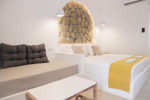a room with two beds and a bench in it at Ladiko Inn Hotel Faliraki -Anthony Quinn Bay in Faliraki