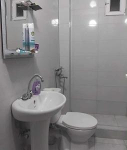 a white bathroom with a toilet and a sink at Khatuna Home in Tsqaltubo