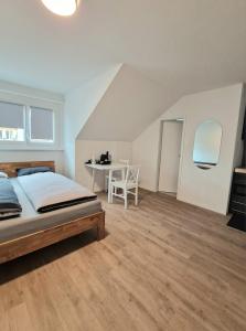 a bedroom with a bed and a table with a chair at Casa Maria Bern in Bern