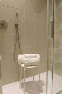 a bathroom with a shower with towels on a stool at Le Volte and Suite in Catania +32 photos
