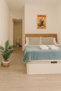a bedroom with a large bed and a potted plant at Suite by Hawkins interior 2A in Algeciras