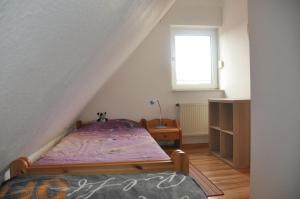 a small bedroom with a bed and a window at FeWo Heitkamp in Dornumersiel