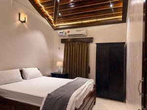 a bedroom with a bed and a window and aitures at Casa De Emilia in Anjuna