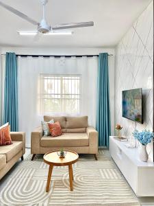 a living room with a couch and a table at Amber Den 3 Bedroom with pool,Buxton in Mombasa +21 photos