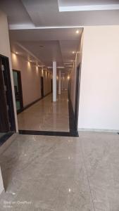 einen Flur eines Gebäudes mit weißen Wänden und Fliesenboden in der Unterkunft Hotel saviraj in Sehore