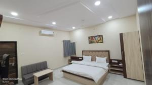 ein Schlafzimmer mit einem Bett und einem Stuhl darin in der Unterkunft Hotel saviraj in Sehore