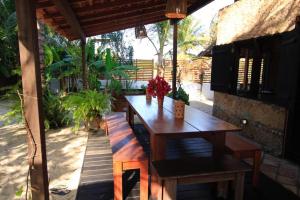a wooden table with flowers on a patio at Casa do Boi, charming house ideally located in Atins ! in Atins