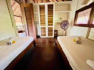 a room with two beds and a fan at Casa do Boi, charming house ideally located in Atins ! in Atins