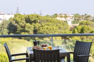 a table with food and drinks on a balcony at AlmeriaSuite Palm Beach in Almerimar