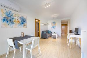 a dining room and living room with a table and chairs at AlmeriaSuite Palm Beach in Almerimar
