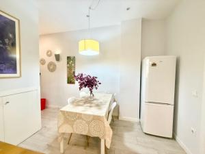 ein Esszimmer mit Tisch und Kühlschrank in der Unterkunft Metro Legazpi 03 AMCH Hospedaje in Madrid