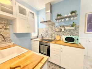 eine Küche mit weißen Schränken und einer Mikrowelle auf der Theke in der Unterkunft Metro Legazpi 03 AMCH Hospedaje in Madrid + 18 Fotos