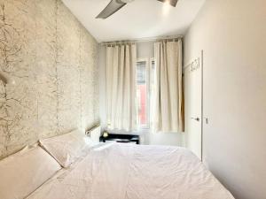 ein Schlafzimmer mit einem weißen Bett und einem Fenster in der Unterkunft Metro Legazpi 03 AMCH Hospedaje in Madrid
