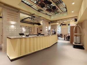 a large kitchen with a long counter in a room at Conscious Hotel Oudegracht in Utrecht