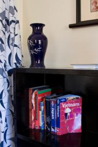 a book shelf with books and a vase on it at At Eleven - La Petite Maison in Sandy Bay