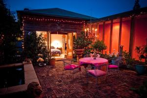 桑迪灣的住宿－十一小莊園住宿加早餐旅館，一个带粉红色桌椅的庭院和一间卧室