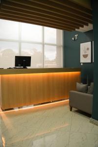 a lobby with a reception desk and a couch at Gran Vale Hotel in Guanhães