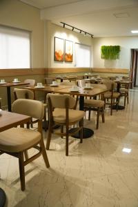 a dining room with wooden tables and chairs at Gran Vale Hotel in Guanhães