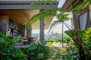 une maison avec un jardin tropical avec une salle à manger dans l'établissement Ningtaru Villa Ubud, à Penginyahan